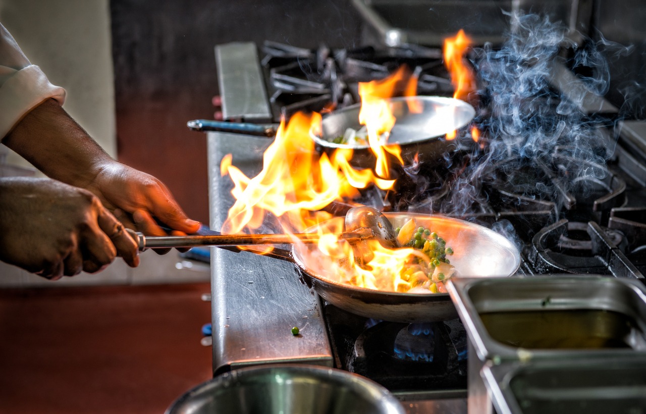 A home chef cooking up a storm over a large fire